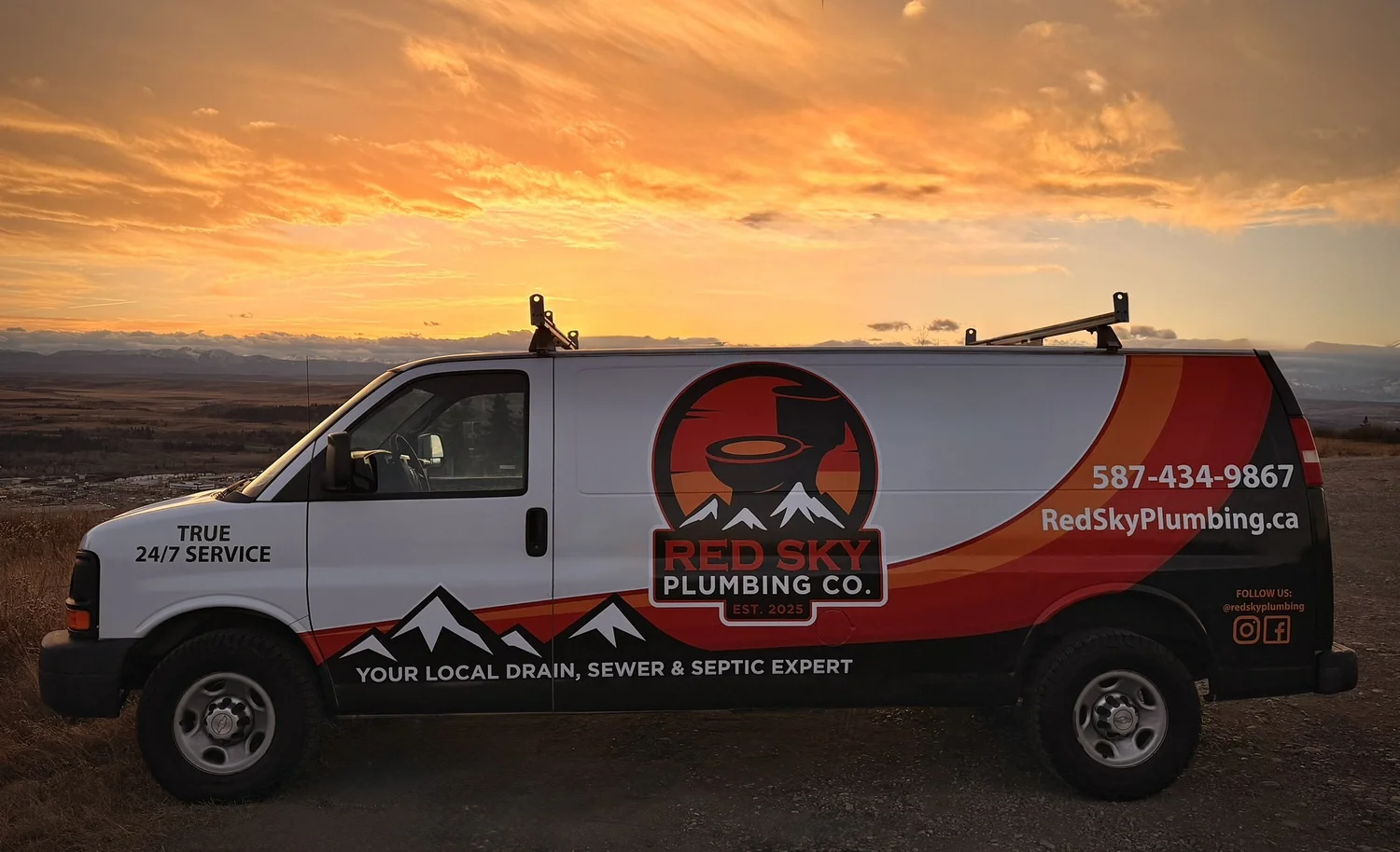 The Red Sky Plumbing van on a bluff above Cochrane, Alberta at sunset, the Rocky Mountains on the horizon.
